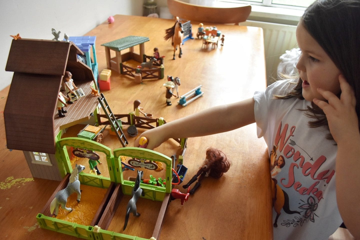 Girl playing with playmobil